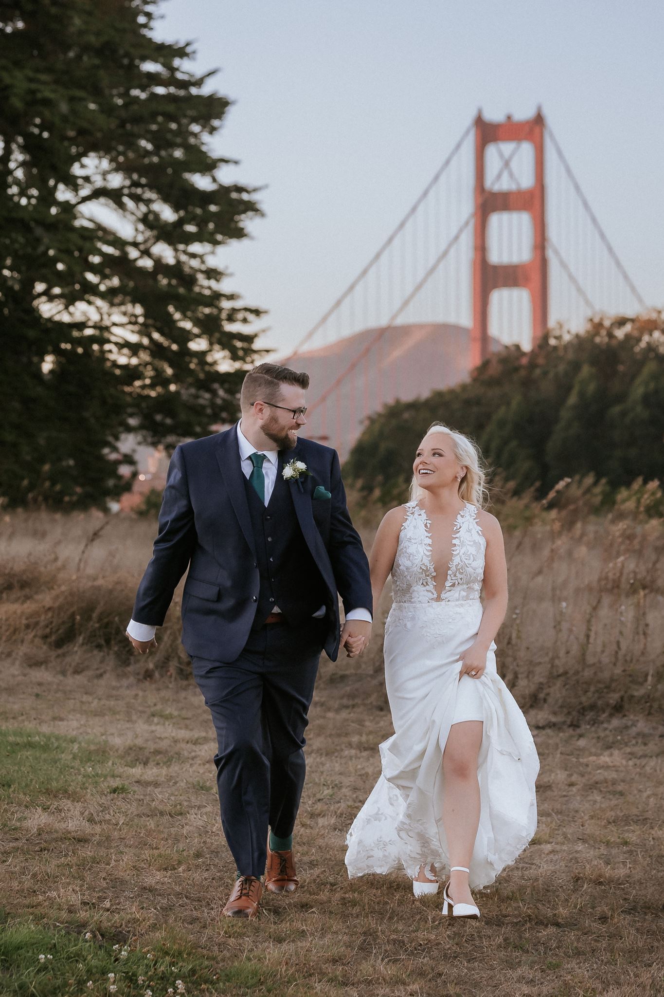 Newlyweds walking through the Presidio during their San Francisco wedding